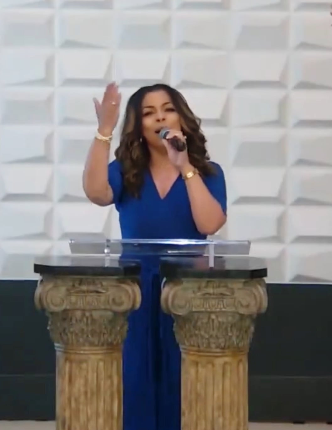 Elizabeth Flynn standing singing and wearing blue dress